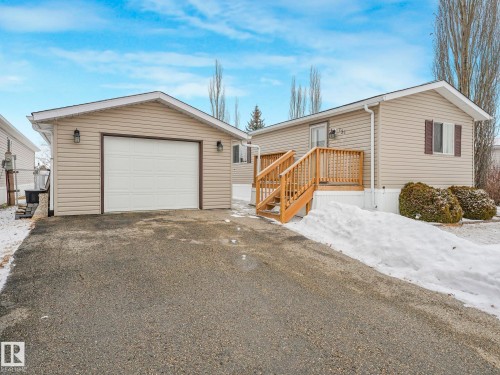Detached garage with horizontal siding, a white panel garage door, and accent lighting - 151 3400 48 Street, Stony Plain, AB - Outdoor With Exterior