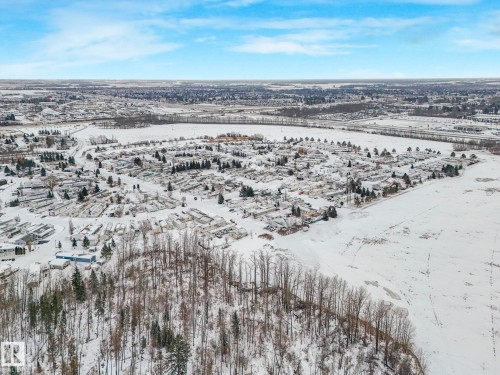 Aerial perspective showcasing a residential community surrounded by expansive snowy terrain - 151 3400 48 Street, Stony Plain, AB - Outdoor With View