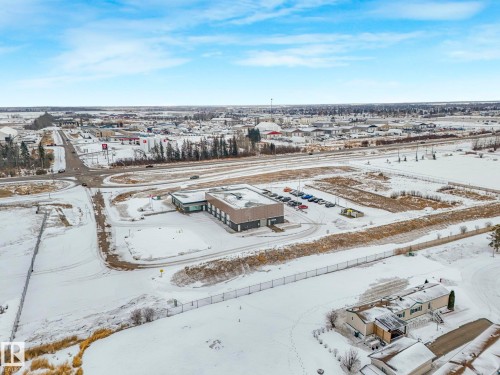 Commercial building featuring a dark facade with lighter accents, multiple windows, and a flat roof - 151 3400 48 Street, Stony Plain, AB - Outdoor With View