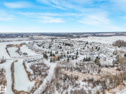 Expansive rural landscape featuring a residential community surrounded by open fields and natural tree lines - 151 3400 48 Street, Stony Plain, AB - Outdoor With View