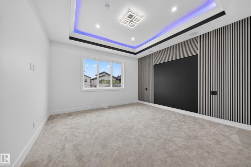 Recessed ceiling with perimeter accent lighting and a modern square chandelier - 4005 39 Street, Beaumont, AB - Indoor Photo Showing Other Room