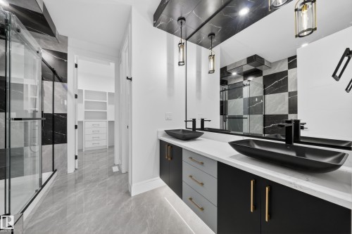 Bathroom featuring a dual vanity with matte black vessel sinks, white countertops, and black cabinetry with gold-tone hardware - 4005 39 Street, Beaumont, AB - Indoor Photo Showing Other Room