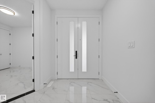 Entryway featuring double doors with frosted glass panels and matte black hardware - 4005 39 Street, Beaumont, AB - Indoor