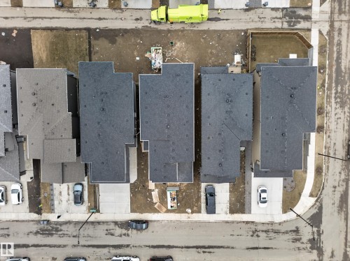 New construction properties featuring asphalt shingle roofing, concrete driveways, and adjacent street parking - 4005 39 Street, Beaumont, AB - Other