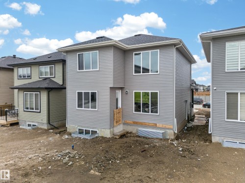 Newly constructed residence featuring grey horizontal siding, a dark shingle roof, and multiple large white-framed windows - 4005 39 Street, Beaumont, AB - Outdoor With Exterior