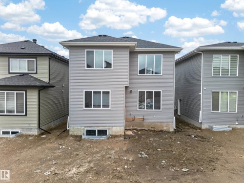 Two-story residential property featuring light gray horizontal siding, multiple white-framed windows, and a dark shingled roof - 4005 39 Street, Beaumont, AB - Outdoor With Exterior