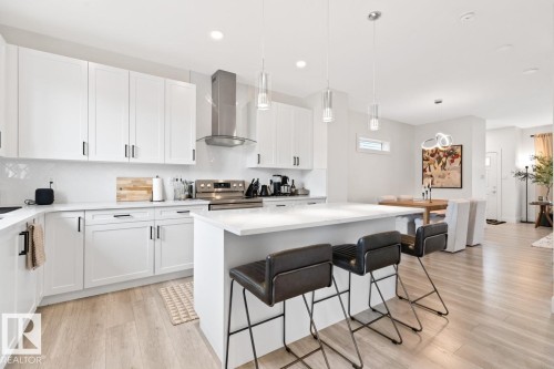 Modern kitchen featuring white shaker-style cabinetry and a large center island - 6023 180 Avenue, Edmonton, AB - Indoor Photo Showing Kitchen With Upgraded Kitchen