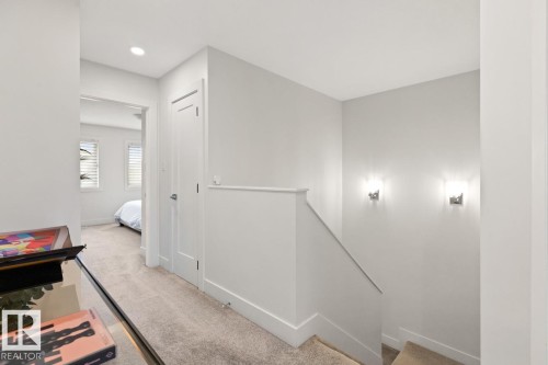 Bright hallway with plush carpet flooring and contemporary wall sconces - 6023 180 Avenue, Edmonton, AB - Indoor Photo Showing Other Room