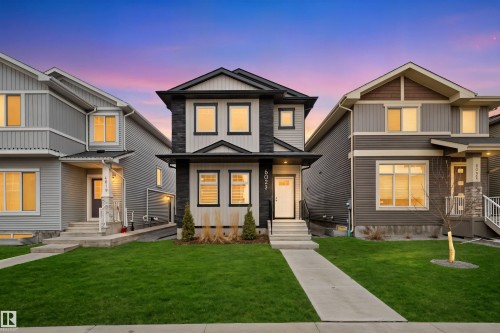 Contemporary two-story home featuring a black and light gray exterior, vertical and horizontal siding, and stone accents - 6023 180 Avenue, Edmonton, AB - Outdoor With Facade