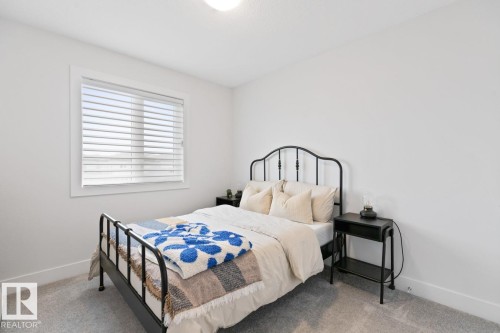 Bedroom featuring light gray carpeting, crisp white walls, and a recessed window with horizontal blinds - 6023 180 Avenue, Edmonton, AB - Indoor Photo Showing Bedroom