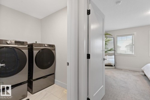 Dedicated laundry area featuring tile flooring and light-toned walls - 6023 180 Avenue, Edmonton, AB - Indoor Photo Showing Laundry Room