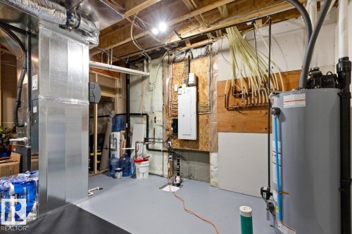 Utility area featuring a water heater, electrical panel, exposed ductwork, and plumbing systems - 6023 180 Avenue, Edmonton, AB - Indoor Photo Showing Basement