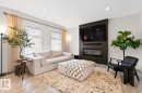 Living area featuring a textured accent wall with an integrated electric fireplace - 6023 180 Avenue, Edmonton, AB  - Indoor Photo Showing Living Room With Fireplace 