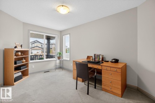 Carpeted room with neutral paint, multiple windows, baseboard trim, and a ceiling-mounted light fixture - 2178 Haddow Drive, Edmonton, AB - Indoor Photo Showing Office