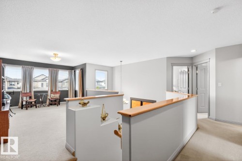 Open concept upper floor featuring abundant natural light, light-colored carpeting, white baseboards, and a neutral color palette - 2178 Haddow Drive, Edmonton, AB - Indoor Photo Showing Other Room