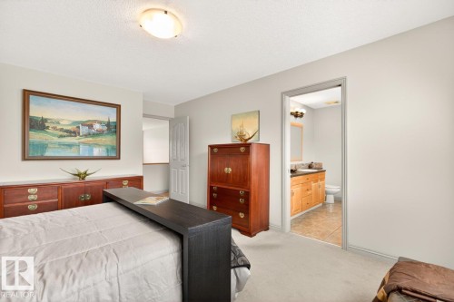 Carpeted bedroom with neutral wall tones and a ceiling-mounted light fixture - 2178 Haddow Drive, Edmonton, AB - Indoor Photo Showing Bedroom