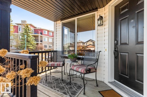 Inviting front porch featuring a dark paneled entry door, white siding, recessed lighting, and a dark wood-finish ceiling - 2178 Haddow Drive, Edmonton, AB - Outdoor With Deck Patio Veranda With Exterior