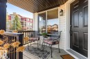 Inviting front porch featuring a dark paneled entry door, white siding, recessed lighting, and a dark wood-finish ceiling - 2178 Haddow Drive, Edmonton, AB  - Outdoor With Deck Patio Veranda With Exterior 