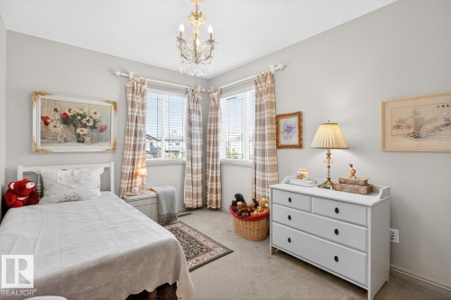 Room featuring two windows with blinds and plaid draperies, a crystal chandelier, and neutral wall paint - 2178 Haddow Drive, Edmonton, AB - Indoor Photo Showing Bedroom