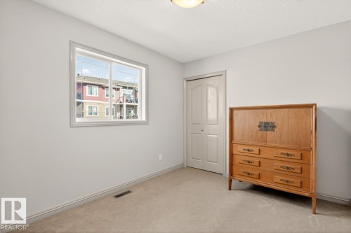 Neutral-toned room featuring a double-paned window, light-colored carpeting, and a bi-fold closet door - 2178 Haddow Drive, Edmonton, AB - Indoor