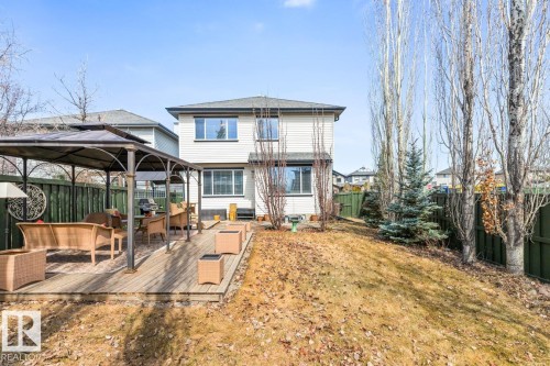 Rear exterior featuring a spacious wooden deck with a gazebo, white siding, and multiple windows - 2178 Haddow Drive, Edmonton, AB - Outdoor