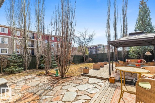 Expansive backyard featuring a natural stone patio, a multi-level wood-finish deck, and mature trees - 2178 Haddow Drive, Edmonton, AB - Outdoor With Deck Patio Veranda