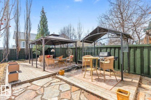 Outdoor living space featuring multiple entertaining areas, including a covered patio deck with a gazebo, a secondary covered deck, and flagstone paving - 2178 Haddow Drive, Edmonton, AB - Outdoor With Deck Patio Veranda