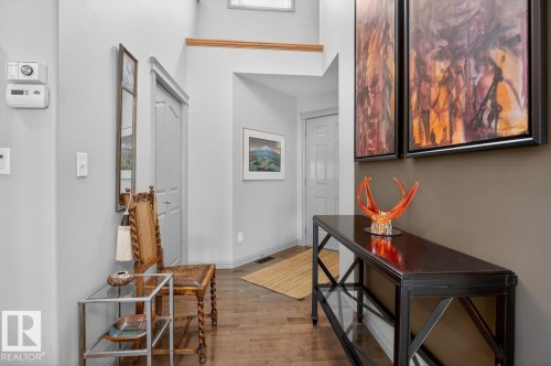 Foyer featuring wood-finish flooring, light grey and brown accent walls, and a high ceiling - 2178 Haddow Drive, Edmonton, AB - Indoor Photo Showing Other Room