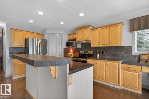 Kitchen featuring light wood cabinetry and an island with breakfast bar - 2178 Haddow Drive, Edmonton, AB - Indoor Photo Showing Kitchen With Double Sink