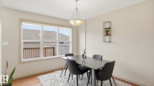 Dining area featuring light wood-finish flooring and a large multi-pane window - 8210 180 Avenue Nw, Edmonton, AB - Indoor Photo Showing Dining Room