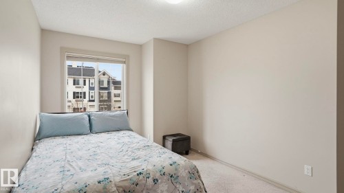 Neutral-toned interior with light carpet flooring and a single window - 8210 180 Avenue Nw, Edmonton, AB - Indoor Photo Showing Bedroom