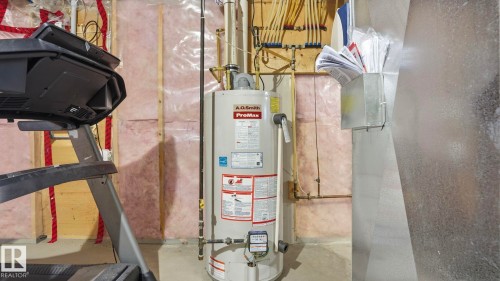 Utility area featuring a water heater, exposed framing, insulation, and visible ductwork - 8210 180 Avenue Nw, Edmonton, AB - Indoor Photo Showing Basement