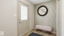 Entryway featuring a panel door with frosted glass insert, textured accent wall, and ceramic tile flooring - 8210 180 Avenue Nw, Edmonton, AB  - Indoor Photo Showing Other Room 