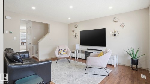 Bright living space featuring wood-finish flooring, recessed lighting, and a neutral wall color - 8210 180 Avenue Nw, Edmonton, AB - Indoor