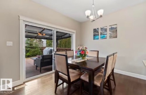 Sliding glass door opening to an outdoor deck area with a covered patio structure - 1944 67 Street, Edmonton, AB - Indoor Photo Showing Dining Room