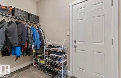 Mudroom entry featuring tiled flooring and a paneled door - 1944 67 Street, Edmonton, AB - Indoor With Storage