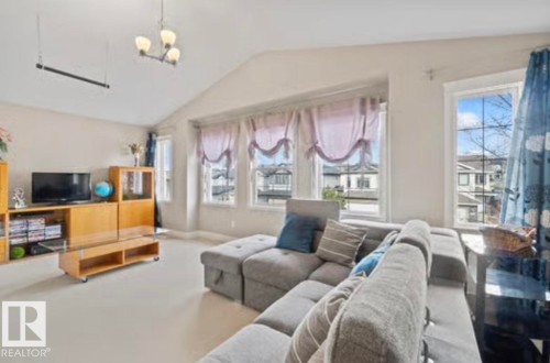 Living area featuring a vaulted ceiling and multiple windows - 1944 67 Street, Edmonton, AB - Indoor Photo Showing Living Room