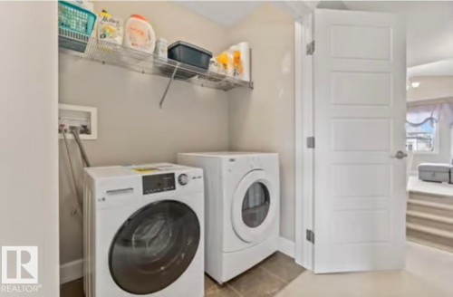 Dedicated laundry area featuring a tile floor, neutral wall paint, and a built-in wire shelving unit - 1944 67 Street, Edmonton, AB - Indoor Photo Showing Laundry Room