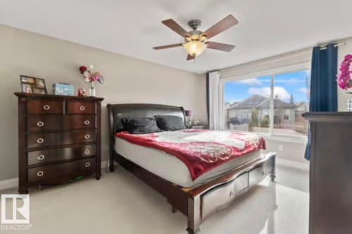 Spacious room featuring light-colored flooring, a large window with white trim, and a ceiling fan with integrated lighting - 1944 67 Street, Edmonton, AB - Indoor Photo Showing Bedroom