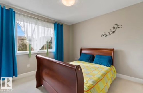 Bright bedroom featuring a large window, neutral wall paint, and white trim - 1944 67 Street, Edmonton, AB - Indoor Photo Showing Bedroom
