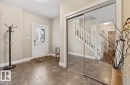 Foyer featuring large format tile flooring, a white entry door with decorative glass, and mirrored sliding closet doors - 1944 67 Street, Edmonton, AB  - Indoor Photo Showing Other Room 