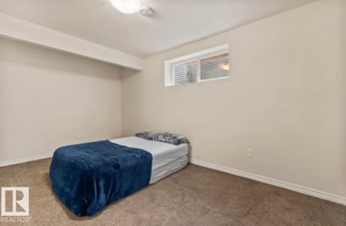 Room featuring neutral wall tones, low-pile carpeting, and a single window with horizontal blinds - 1944 67 Street, Edmonton, AB - Indoor Photo Showing Bedroom