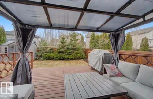 Expansive outdoor deck featuring wood-finish flooring, a covered gazebo structure, and privacy curtains - 1944 67 Street, Edmonton, AB - Outdoor With Deck Patio Veranda With Exterior