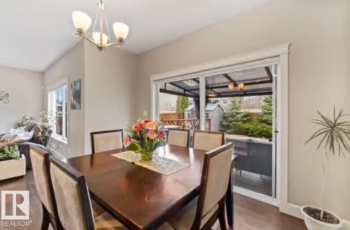 Dining area with wood-finish flooring and a contemporary chandelier - 1944 67 Street, Edmonton, AB - Indoor Photo Showing Dining Room