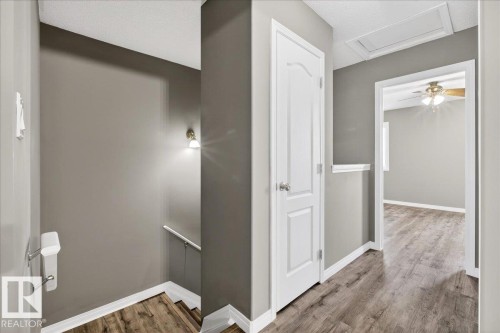 Hall featuring an upstairs landing, wood finished floors, and attic access - 150 Acacia Circle, Leduc, AB - Indoor Photo Showing Other Room