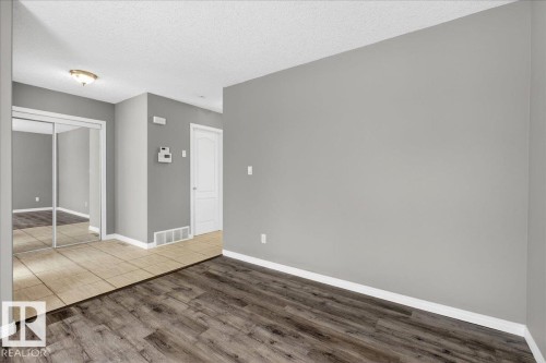 Spare room featuring a textured ceiling and wood finished floors - 150 Acacia Circle, Leduc, AB - Indoor Photo Showing Other Room