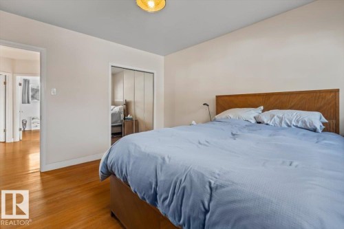 Hardwood flooring complements light-toned walls - 10756 133 Street, Edmonton, AB - Indoor Photo Showing Bedroom