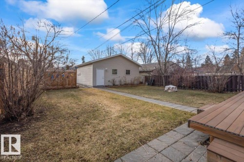Detached garage with horizontal siding, a side entry door, and two small rectangular windows - 10756 133 Street, Edmonton, AB - Outdoor
