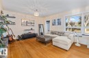 Living area featuring wood-finish flooring, light-toned walls, and a decorative ceiling light fixture - 10756 133 Street, Edmonton, AB  - Indoor Photo Showing Living Room 