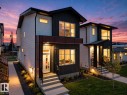 Modern architectural exterior featuring contrasting siding and trim, multi-pane windows, front entryway lighting, concrete front steps, and a manicured lawn - 10913 159 Street, Edmonton, AB  - Outdoor 